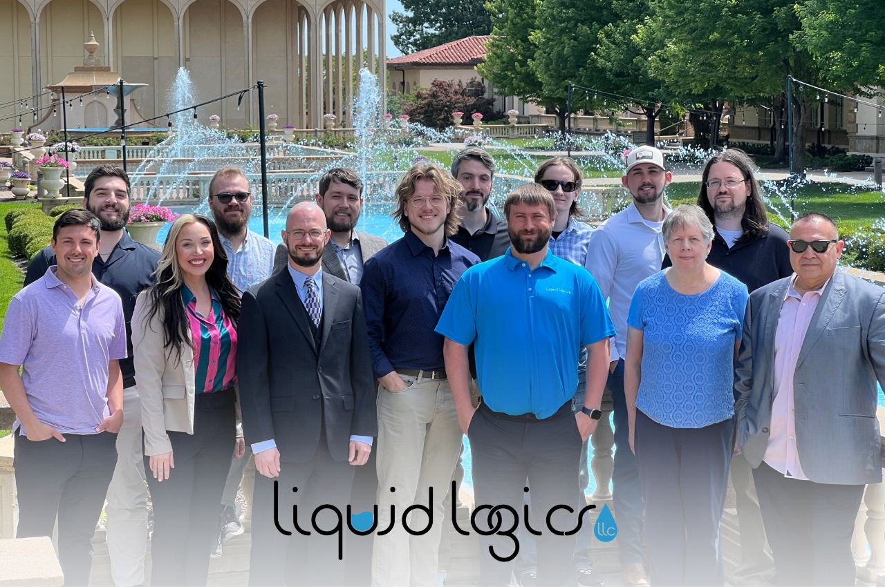 The Liquid Logics team outdoors in front of the company logo